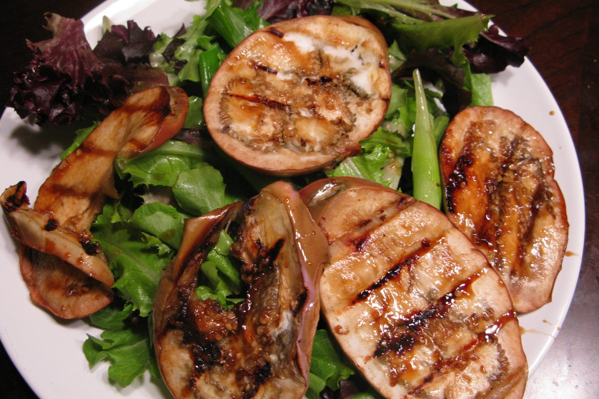 Grilled eggplant slices over salad greens with miso dressing