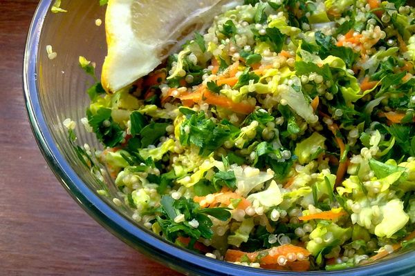 Quinoa tabbouleh with herbs and vegetables in a glass bowl