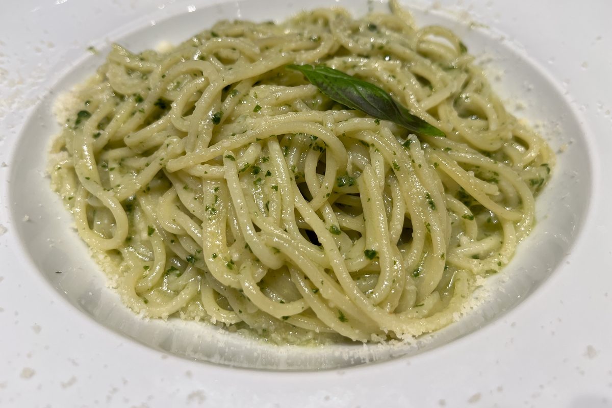 Plate of spaghetti tossed in green pesto